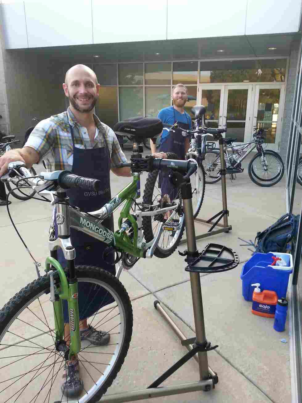 2 staff working on bikes outside